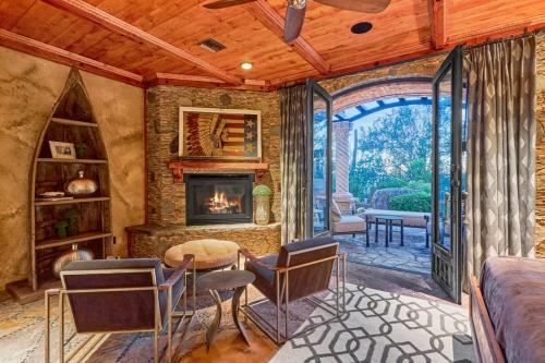 a living room with a fireplace and a table and chairs at Castle On Black Mountain breathtaking panoramic views and outdoor entertainment in Cave Creek