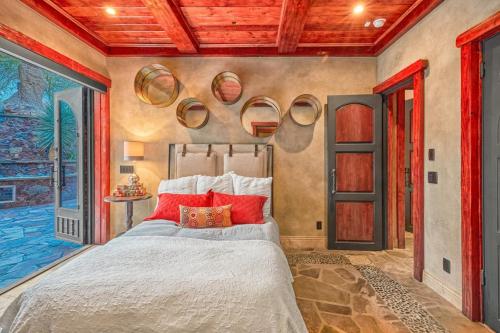 a bedroom with a large bed with red pillows at Castle On Black Mountain breathtaking panoramic views and outdoor entertainment in Cave Creek