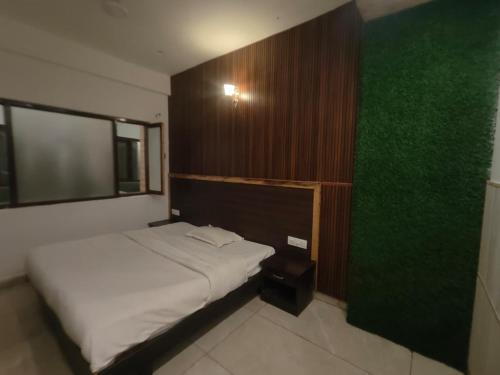 a bedroom with a white bed and a green wall at Jolly Luxury Resort in Gangtok