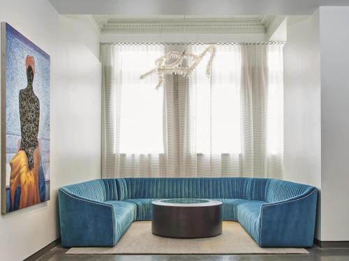 a living room with a blue couch and a table at 21c Museum Hotel Lexington in Lexington