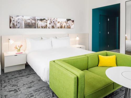 a bedroom with a large bed and a green couch at 21c Museum Hotel Lexington in Lexington