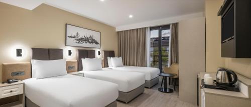 a hotel room with two beds and a television at Garner Hotel Istanbul - Airport Arnavutkoy by IHG in Istanbul
