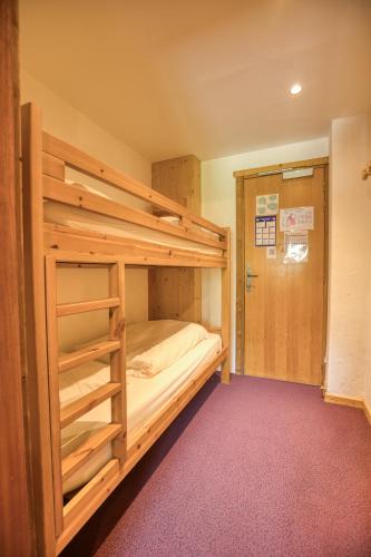 a bedroom with a bunk bed with a ladder at Epicéa Lodge Hôtel et Camping in Pralognan-la-Vanoise