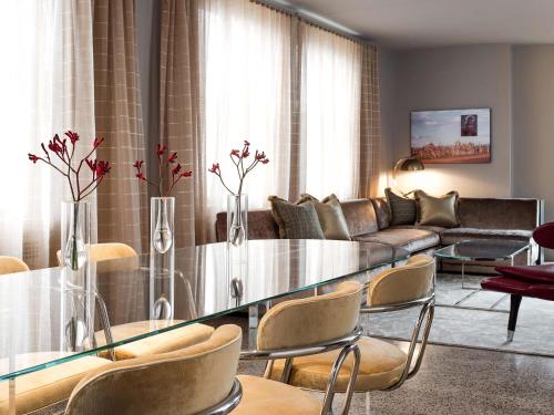 a living room with a glass table and a couch at 21c Museum Hotel Durham in Durham