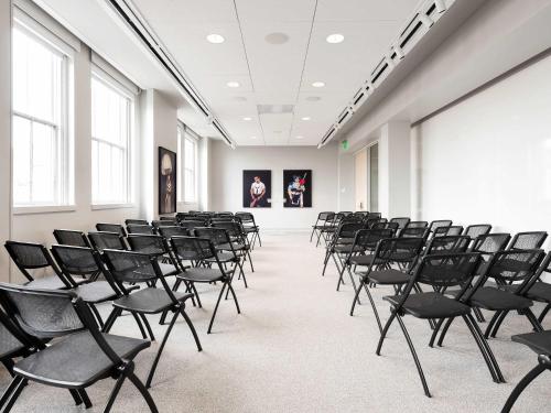 an empty room with black chairs in a building at 21c Museum Hotel Durham in Durham