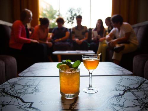 a drink on a table with a group of people at 21c Museum Hotel Durham in Durham