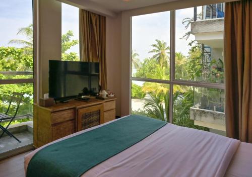 a bedroom with a bed and a large window at Seasalter Maldives in Hulhumale