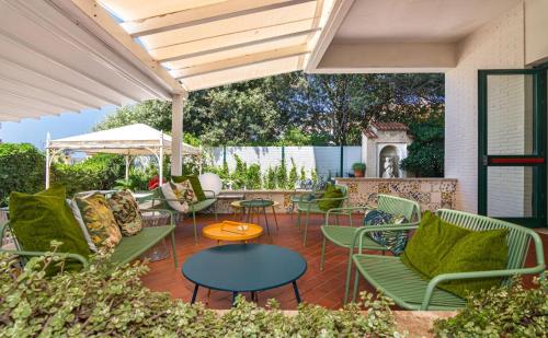a patio with chairs and tables and an umbrella at Hotel Joseph in Marina di Pietrasanta