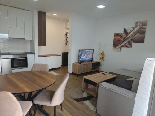 クラグイェヴァツにあるSunshine III Apartmentのキッチンとテーブルとソファのあるリビングルーム