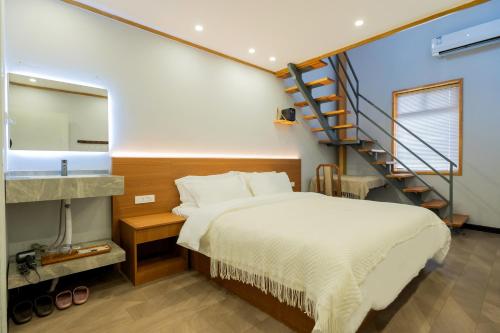 a bedroom with a bed and a staircase at The Lu Village Retreat in Guilin