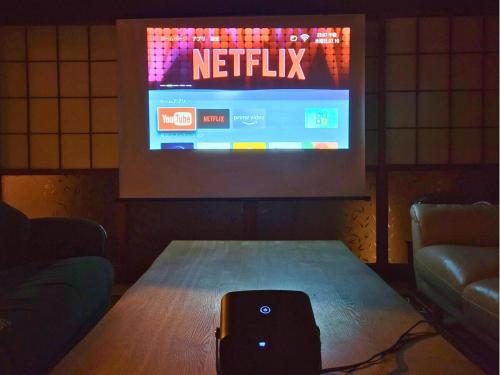 a table with a television in a room at 古民家サウナandバーベキュー TK亭 in Ichihara