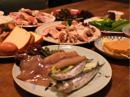 a table full of plates of food with meat and vegetables at 古民家サウナandバーベキュー TK亭 in Ichihara