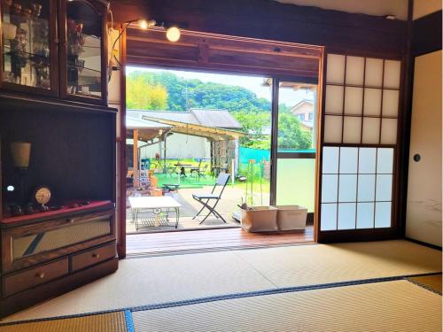 an open door into a room with a patio at 古民家サウナandバーベキュー TK亭 in Ichihara