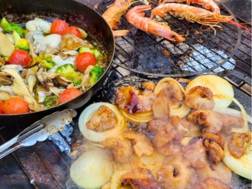 a pan of food with shrimp and vegetables on a grill at 古民家サウナandバーベキュー TK亭 in Ichihara