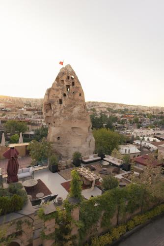 a large rock formation with a city in the background at Carus Cappadocia in Goreme