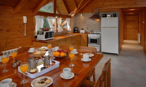 a kitchen with a wooden table with fruit on it at La Estancia Cabañas in Villa La Angostura