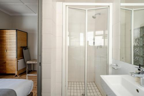 a bathroom with a shower and a sink at Camps Bay Village in Cape Town