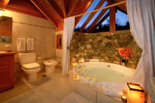 y baño con bañera y aseo. en La Estancia Cabañas en Villa La Angostura
