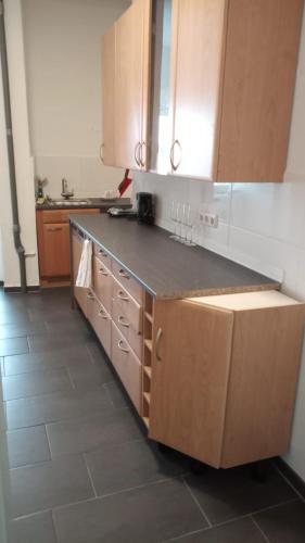 a kitchen with wooden cabinets and a counter top at Zimmer am Hauptbahnhof 1 in Minden