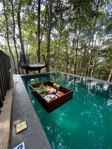 una piscina con una mesa en el agua en Citron Villa, en Koggala