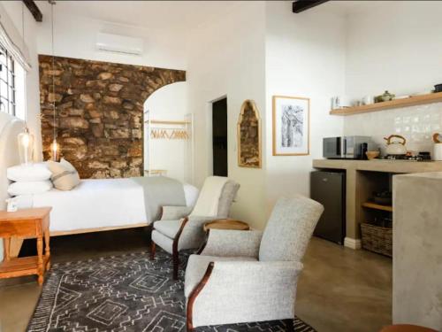 une chambre avec un lit, une table et des chaises dans l'établissement Nooitgedacht Guest Farm Cottages, à Kayamnandi