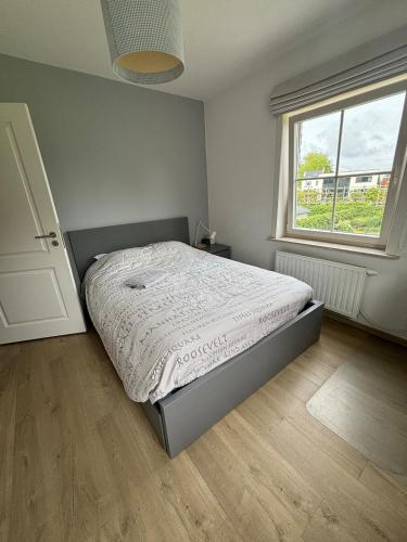 a bedroom with a bed and a window at Brabant house with pool in Rixensart