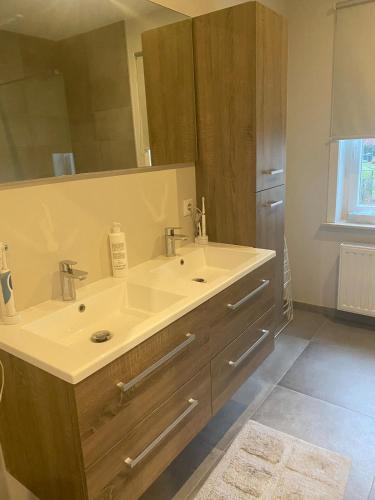 a bathroom with a sink and a large mirror at Brabant house with pool in Rixensart