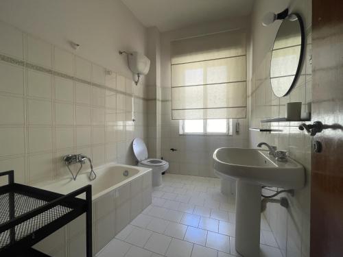 a bathroom with a tub and a sink and a toilet at The Greek House RC in Reggio Calabria