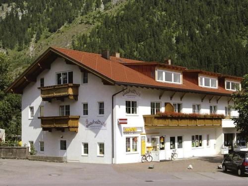 a large white building with a red roof at Apartment in Bichlbach at the lake in Bichlbach