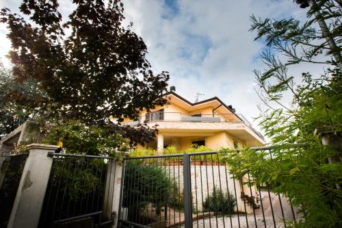 a yellow house with a fence in front of it at B&B Casa Ciarpella in Montegranaro
