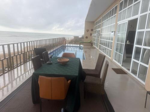 a balcony with a table and a swimming pool at The Lawton in Cape Coast