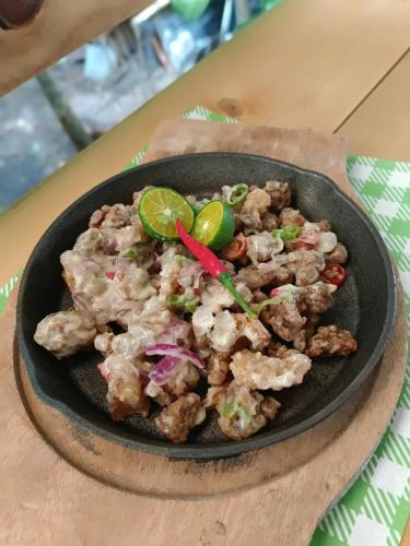 Kyle's Bed and Breakfast DMall Boracay في بوراكاي: وعاء من الطعام على طاولة خشبية