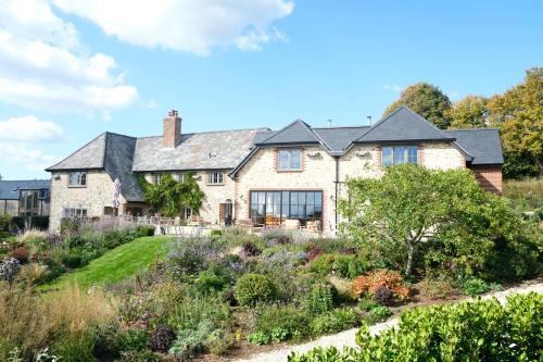 a house with a garden in front of it at Louma Country Hotel in Wootton Fitzpaine