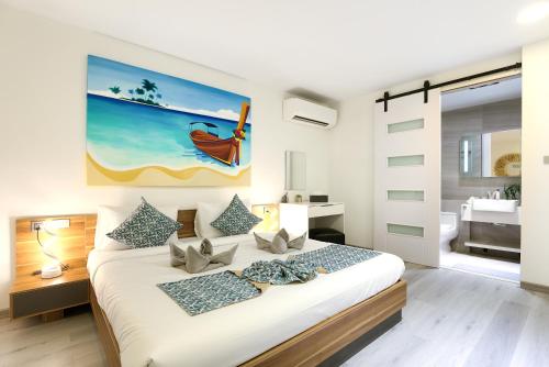 a bedroom with a bed with a painting on the wall at Massive 4 Bedroom with Cinema Room and Gym in Koh Samui 