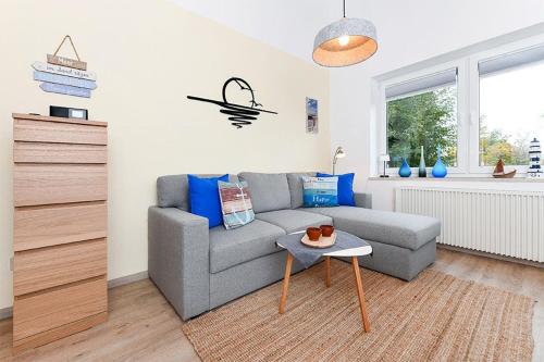 a living room with a couch and a table at Ferienwohnung Happynest in Bensersiel