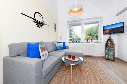 a living room with a gray couch and a table at Ferienwohnung Happynest in Bensersiel