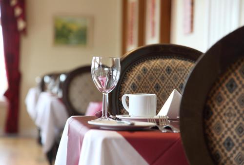 a table with a wine glass and a cup on it at The Imperial Hotel in Fort William