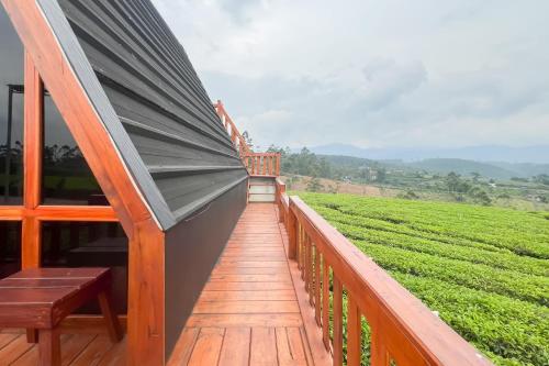 a wooden balcony with a view of a green field at S Tilu Heroy Hill Resort Pangalengan Bandung RedPartner in Pengalengan