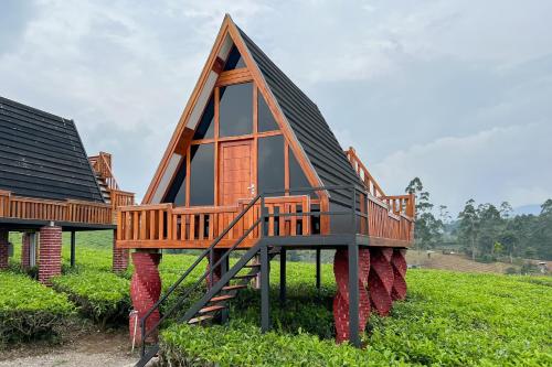 a house with a deck on top of a field at S Tilu Heroy Hill Resort Pangalengan Bandung RedPartner in Pengalengan