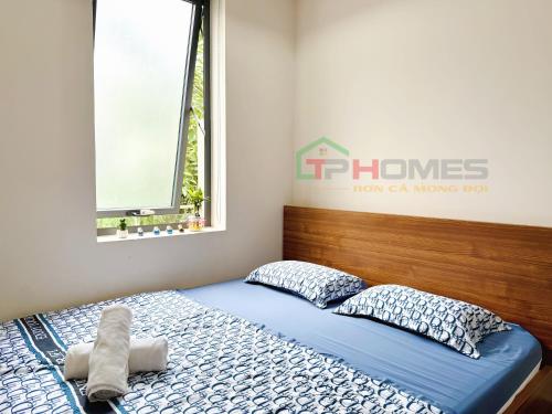 a bedroom with a bed with blue sheets and pillows at TPHomes Mystery in Ho Chi Minh City