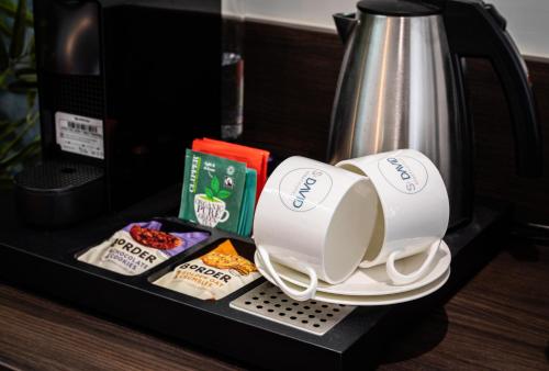 a coffee maker with two cups and some food at The Old Brewery - A St David Aparthotel in Barrow in Furness