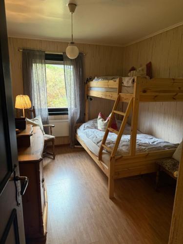 Un dormitorio con una litera y un escritorio. en Fossen bratte chalet, en Eikjedalen