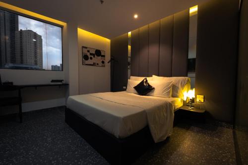 a hotel room with a bed and a window at Love in the Atlantis Hotel in Hanoi