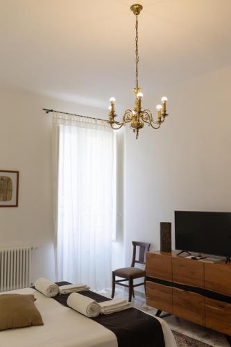 a bedroom with a bed and a chandelier at B&B Don Alessandro in Surbo