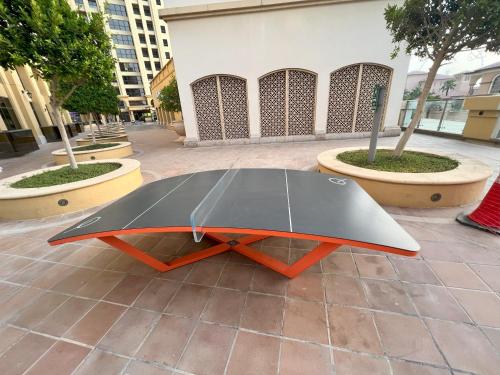 a black and orange table sitting on a sidewalk at Sadaf 7 House Jbr for tourists - BEDSPACE in Dubai