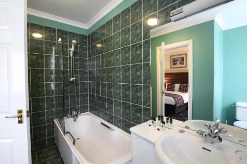 La salle de bains est pourvue d'une baignoire, d'un lavabo et d'une baignoire. dans l'établissement The Imperial Hotel, à Fort William