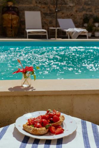 a plate of food on a table next to a pool at B&B Don Alessandro in Surbo