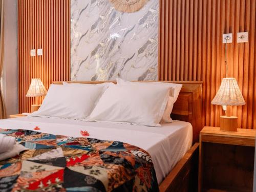 a bedroom with a bed and a painting on the wall at Brezze Garden Village in Mataram