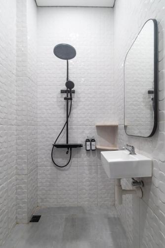 a white bathroom with a sink and a mirror at Gomini Stay in Cebongan