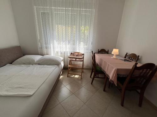 Un dormitorio con una cama y una mesa y sillas. en Apartment Antonia, en Selce